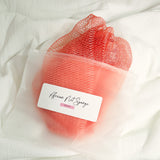 Light pink African net sponge in a clear zip bag with a product label on a white background
