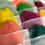 Assorted colorful African net sponges in clear plastic product bags